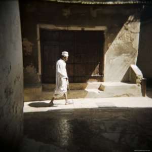 Old Man Walking Down Shady Street in Traditional White Robes, Stone 