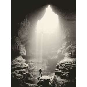  A Man Stands in Front of a Skylit Cave Waterfall Stretched 