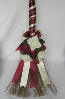The beautiful handcrafted wedding broom is wrapped in satin ribbon and 